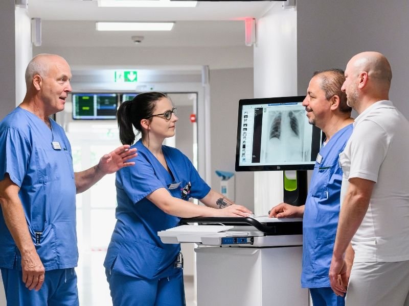 Ärzte und Therapeuten besprechen sich an einem digitalen Visitenwagen