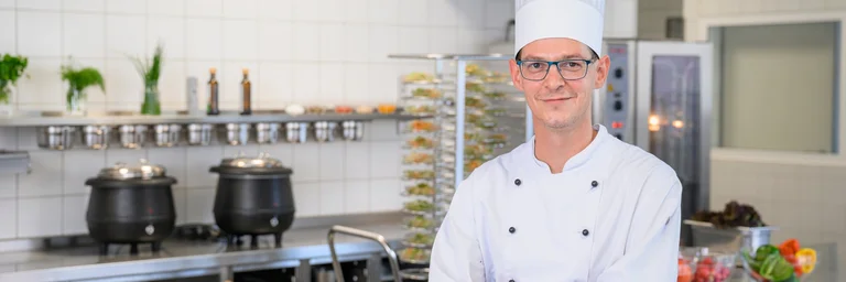 Portraitaufnahme eines Kochs in einer Großküche