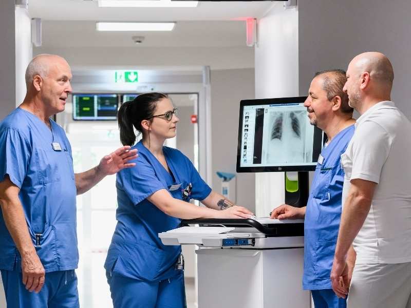 Ärzte und Therapeuten besprechen sich an einem digitalen Visitenwagen