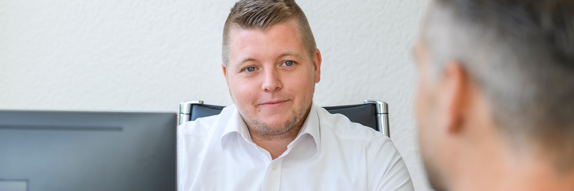 Ein Verwaltungsmitarbeiter im Gespräch mit einem Patienten