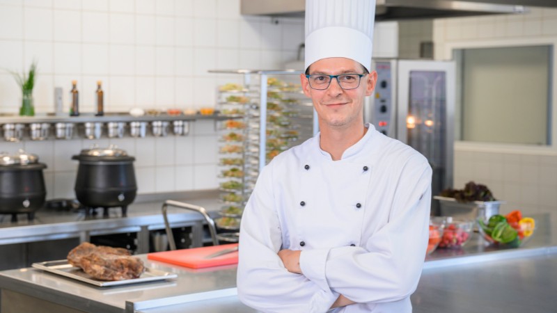 Portraitaufnahme eines Kochs in der Großküche